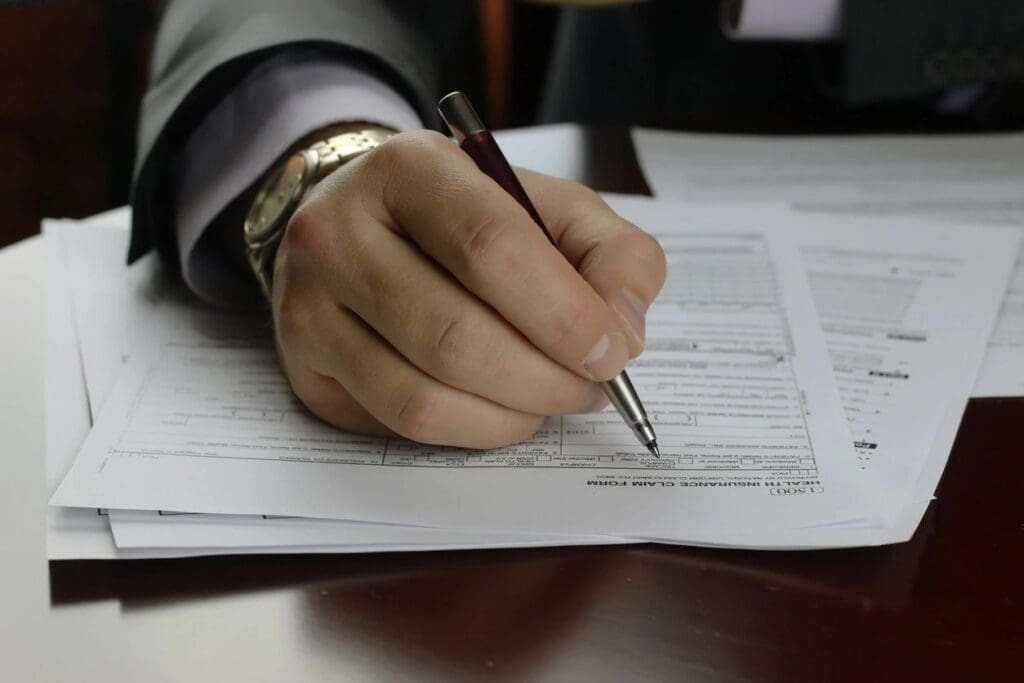 A person filling out a form with a pen