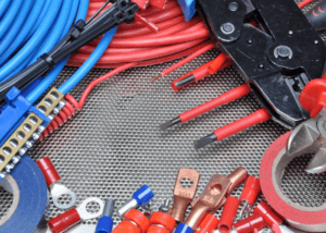 Various electrical connectors and tools arranged on a textured surface.