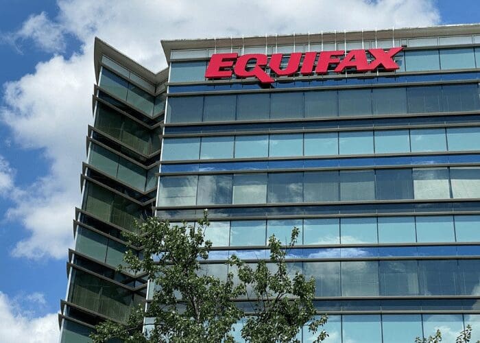 Equifax office building with red logo on a glass facade.