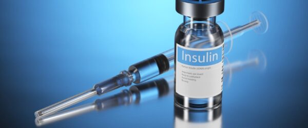 Insulin vial and syringe on blue background.