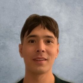 Young man with brown hair and a neutral expression.