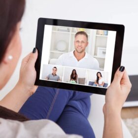 Person holding tablet during group video call