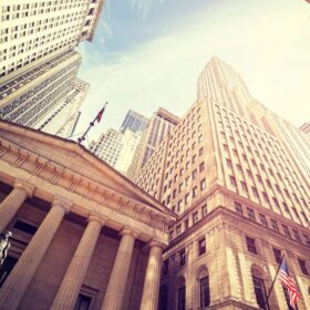 Historic building surrounded by towering skyscrapers.