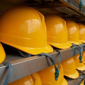 Rows of yellow hard hats on shelves